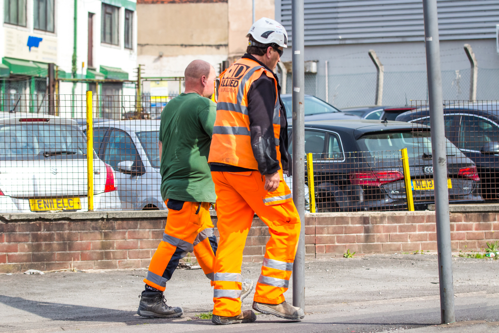 Skilled Worker Visa vs Intra-Company Transfer: A picture showing two UK Skilled worker strolling after work on the street of UK. 