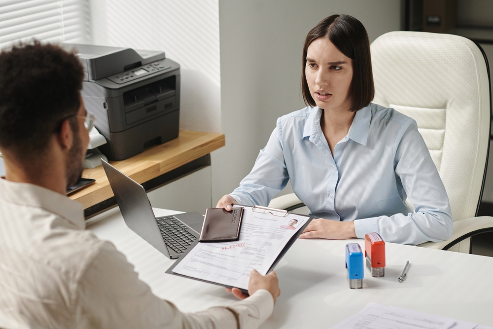 How to Avoid UK Visa Rejection: A picture showing a consular officer in an interview session with UK visa applicant.