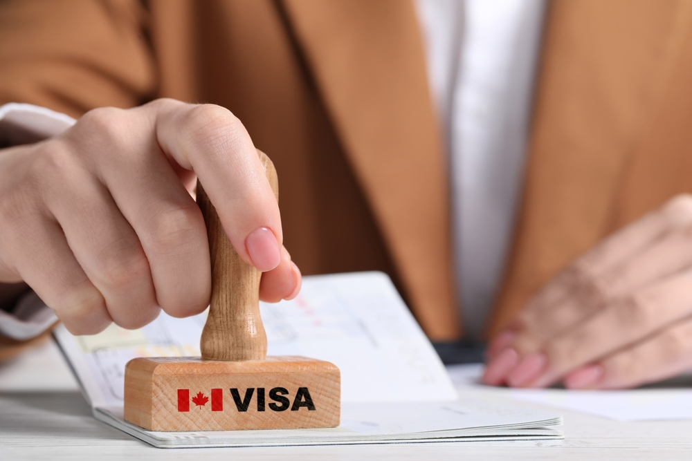 Canada Family Reunion Visa: A picture showing a Canada consular officer holding visa stamp.