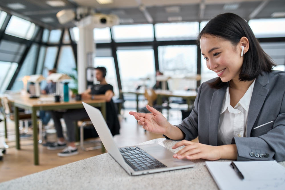 The Essential Guide to Remote Job Performance Reviews: Picture of a smiling lady working on a laptop