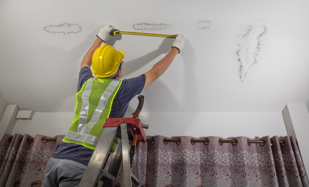 Best and Worst Industries for Remote Work: Worker fix leaking pipe in ceiling ,close-up of a stain on the ceiling. 