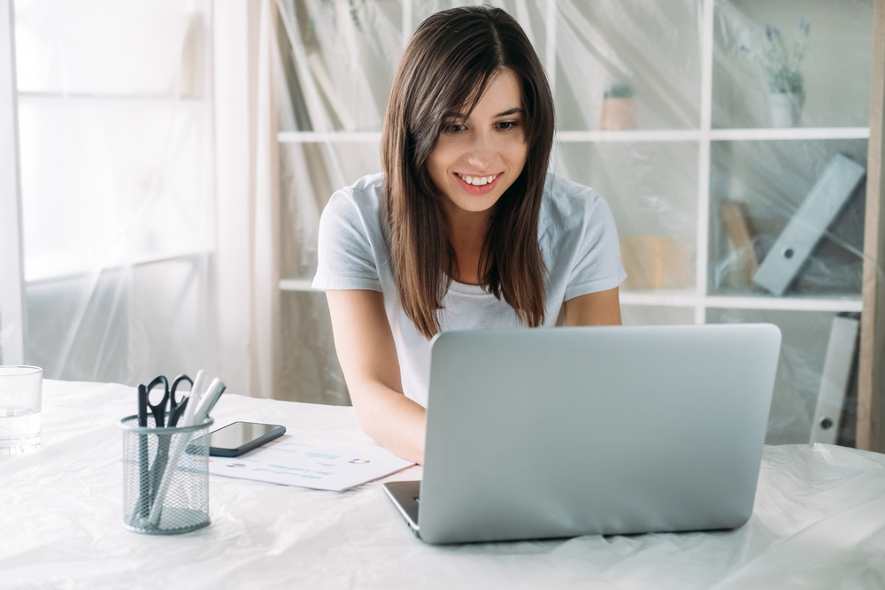 How to Avoid Time-Wasting Activities in Your Remote Workday: Picture of a female freelancer working remotely on her laptop