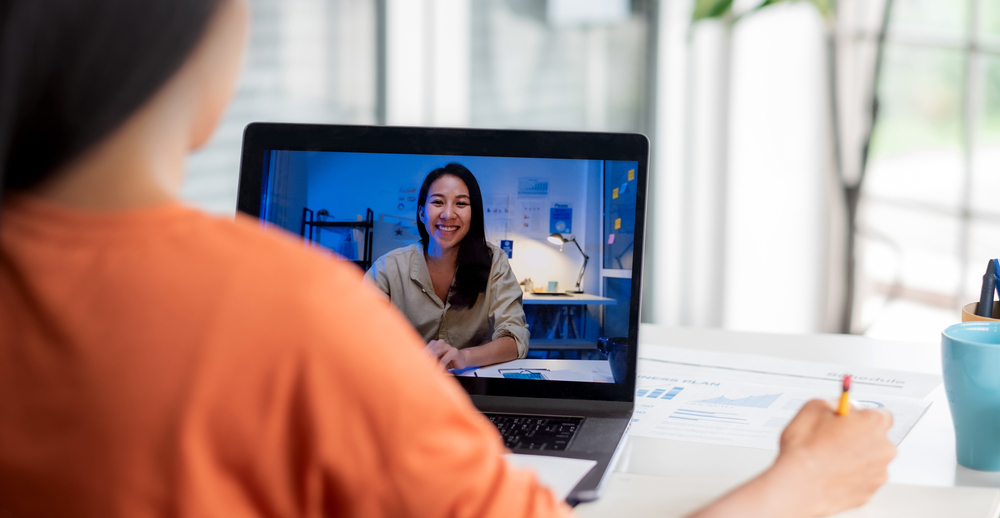 Things to Know Before Working Remotely from a Different Time Zone: Picture of a female freelancer in a video international conference from home.